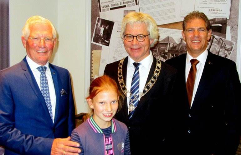 Piet Kapenga, kleindochter Sigrit, burgemeester Ferd Crone en Sikko Kapenga. Op de achtergrond het tableau met daarop het ontstaan van het Bildtsch Meubelhuis van heit/pake Sikko Kapenga sr. in 1934.