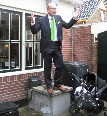 Joop Atsma, op de regenwaterbak de bezoekers begroetend.